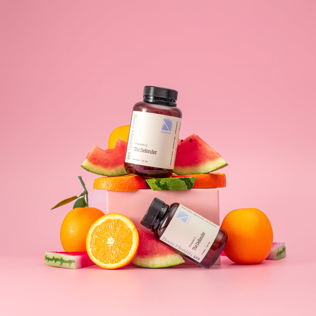 the defender vitamin c 1000mg with watermelons and oranges on a pink background