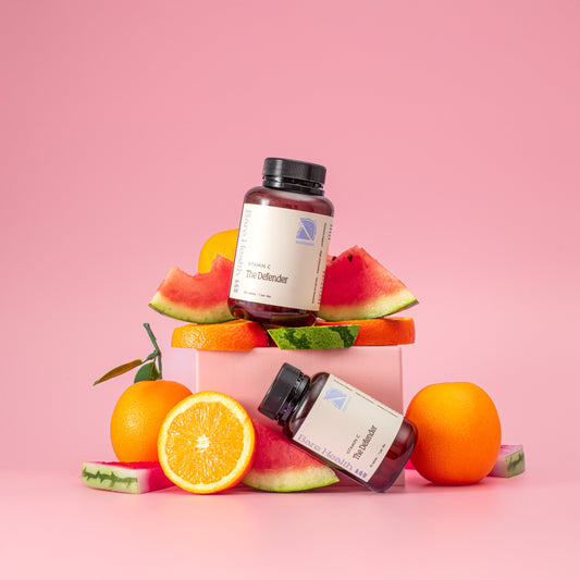 the defender vitamin c 1000mg with watermelons and oranges on a pink background