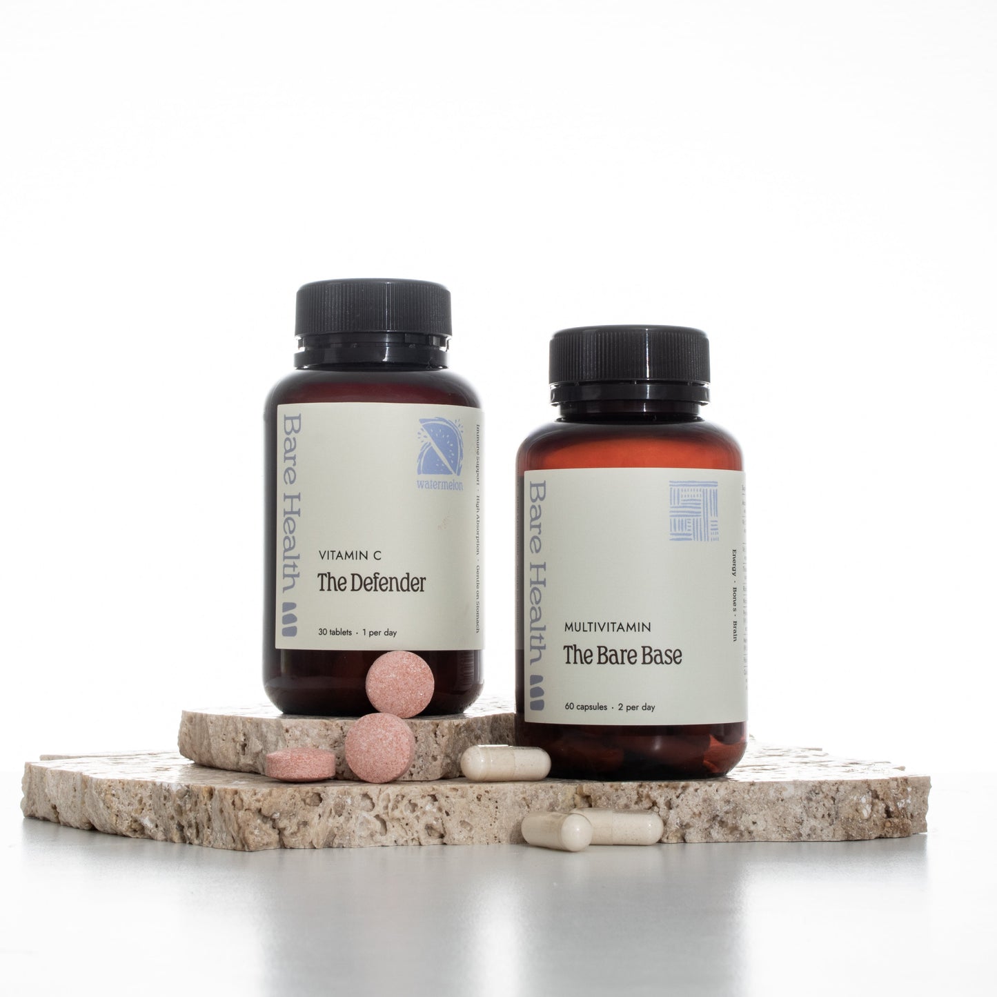 Two supplement bottles with pills on a light background