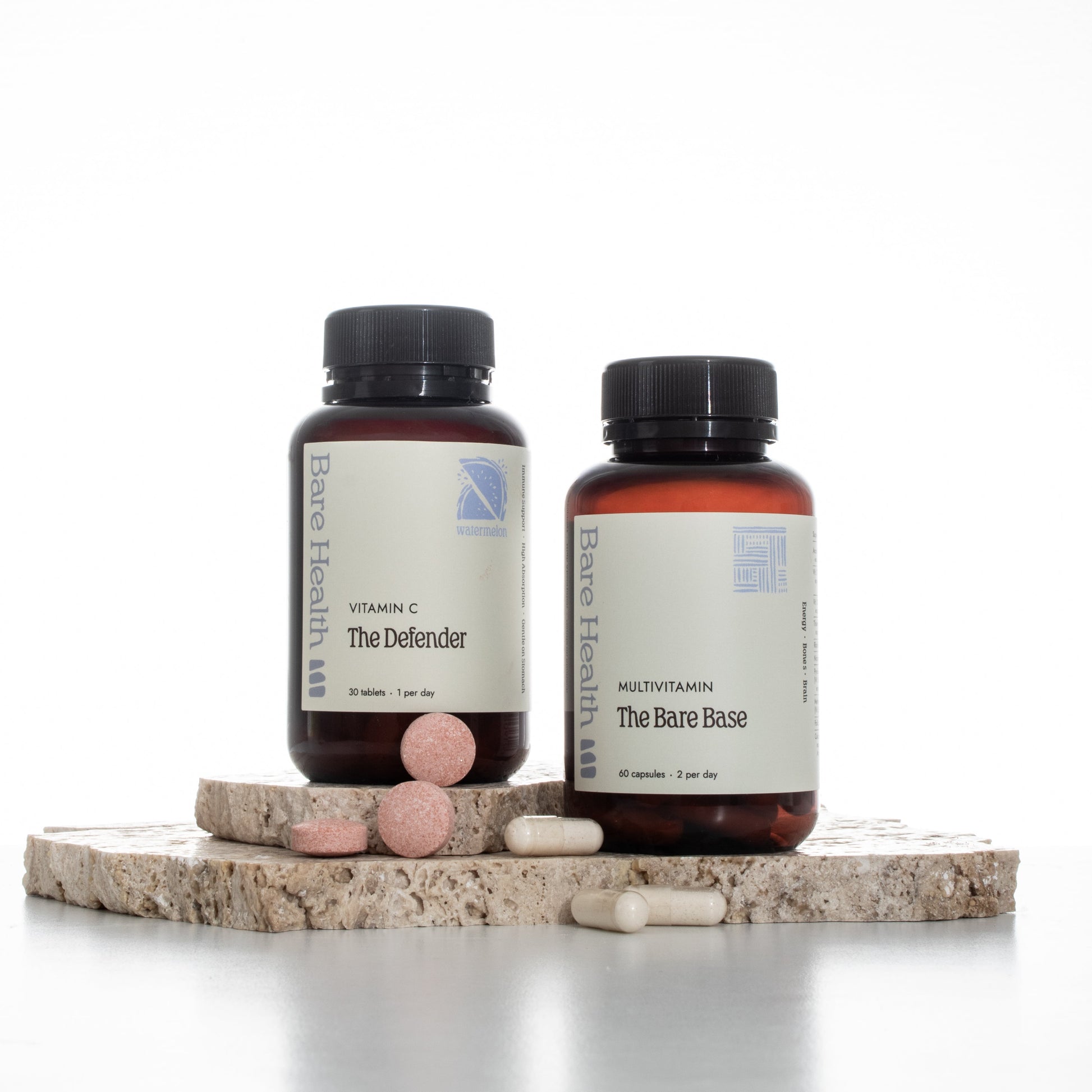 Two supplement bottles with pills on a light background