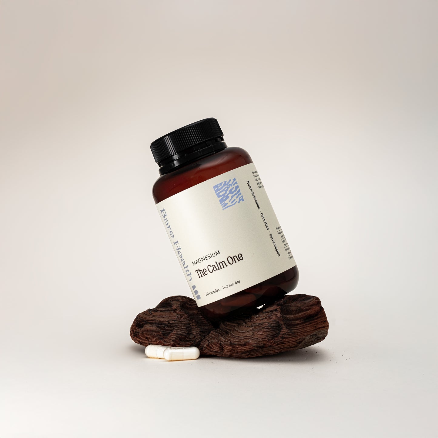 Bottle of 'The Calm One' supplement with a wooden stand on a light gray background